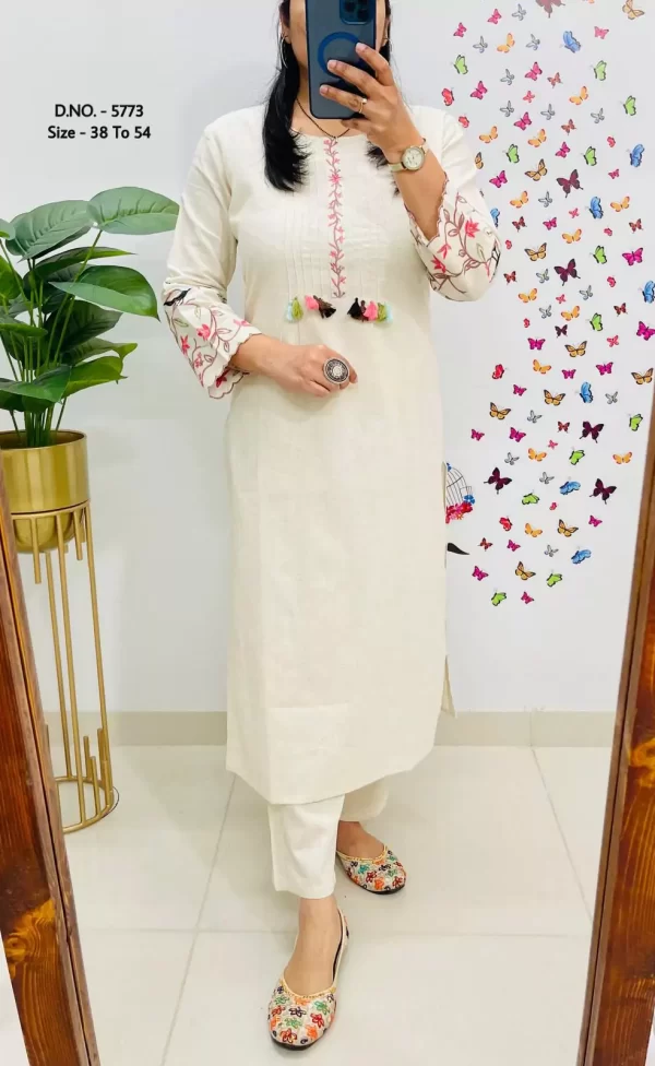 Girl wearing a white Elegant Cotton Slub Kurti Pant Cord Set – Hand Aari Embroidery & Pintex Work from dailyimprovise, and posing for photo