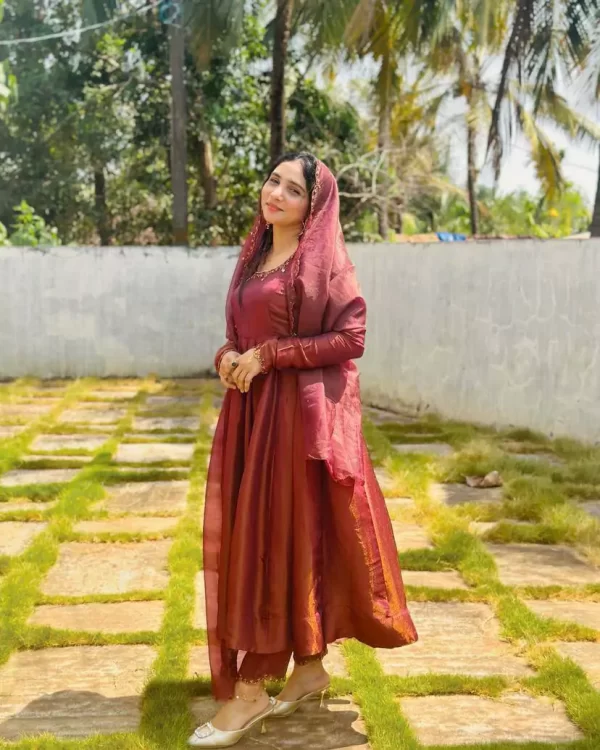 Girl wearing maroon Designer Jimmi Chhoo Anarkali Set with Sequins Embroidery & Dupatta from dailyimprovise and having dupatta over head